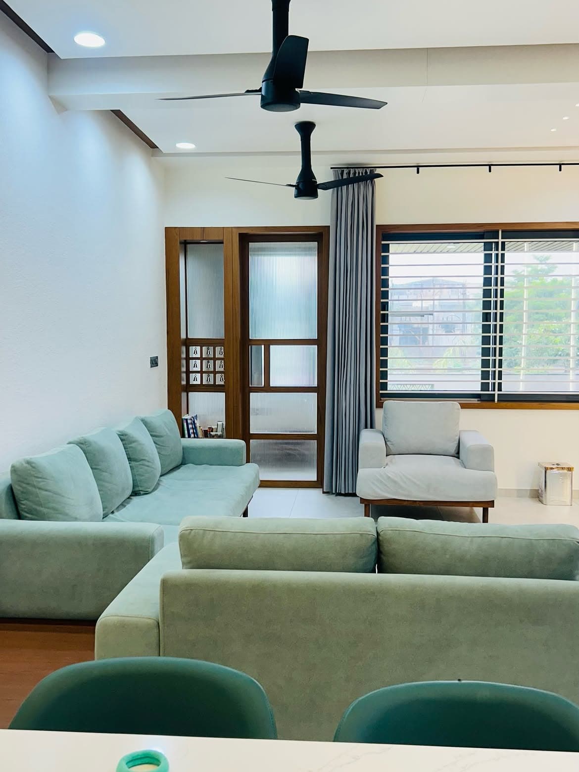 Living room with warm cabinetry, a media wall and soft seating