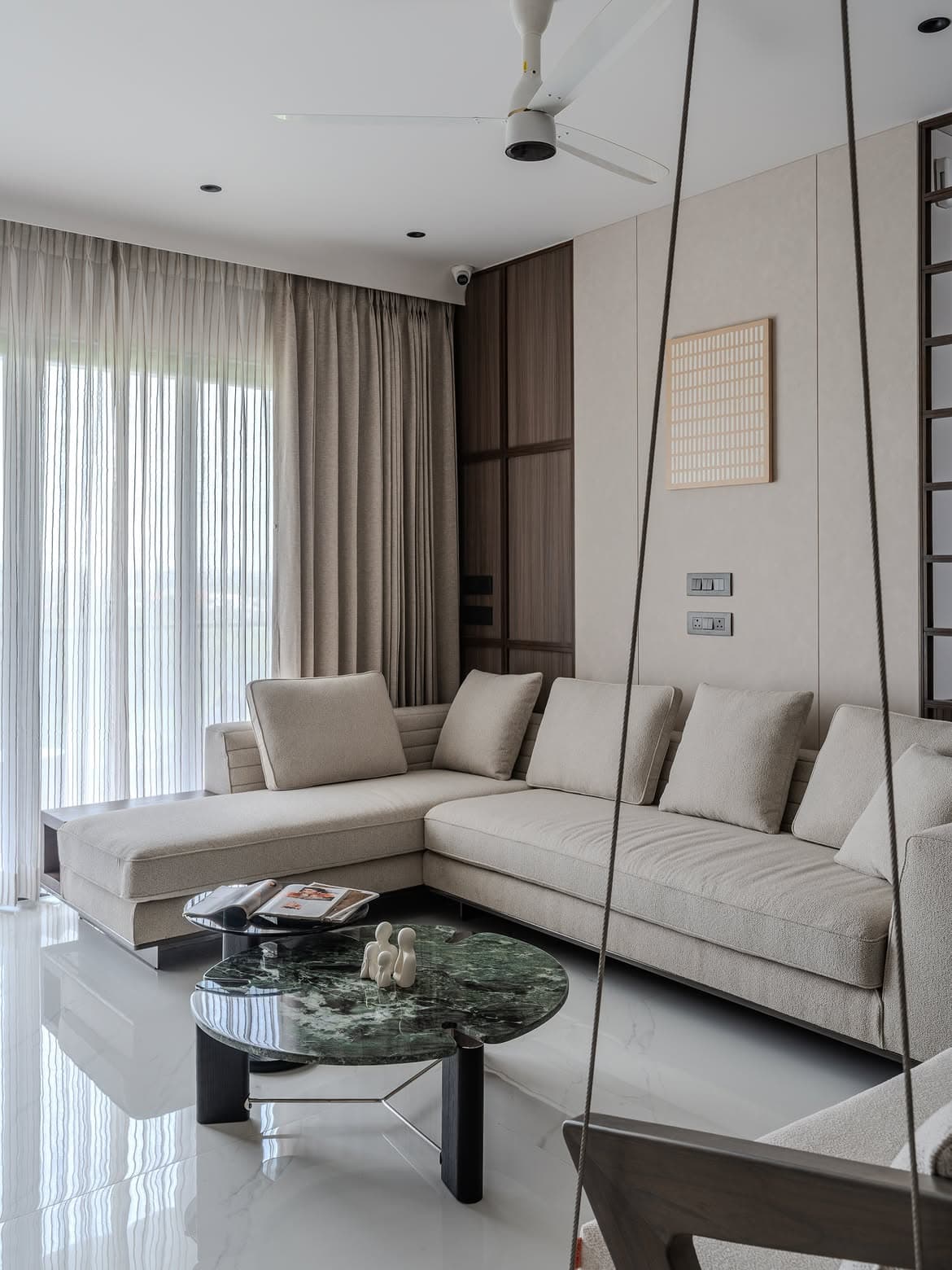 Living room with a swing chair, marble floor and soft daylight